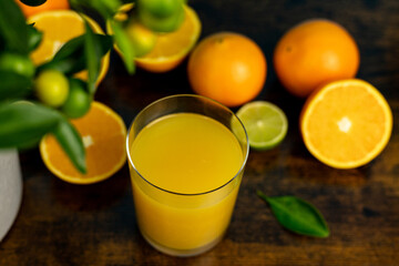 Close-up of cut oranges on a table. Orange juice in a glass