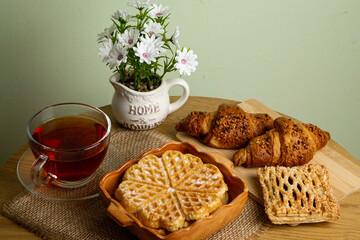 Waffle, croissants and tea.Tea drinking.Fresh homemade pastries. Waffle close-up