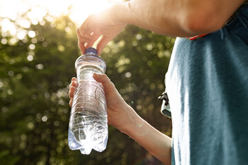 Person opening a bottle of drinking water 