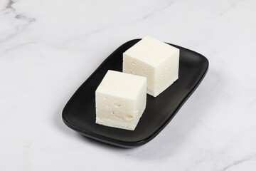 Bird's milk, souffle in the shape of a cube. On a plate. White background	