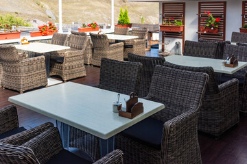 Terrace seating area, Rows of wicker furniture on a terrace with mountain views. Ready for guests.