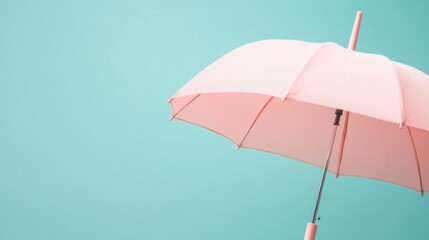 Obraz premium Soft pink umbrella against a teal backdrop
