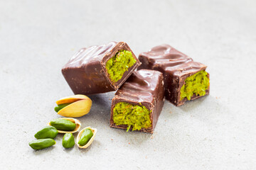 Modern Dubai chocolate. Chocolate candy bar with crispy kataifi filling and pistachio paste. Light...