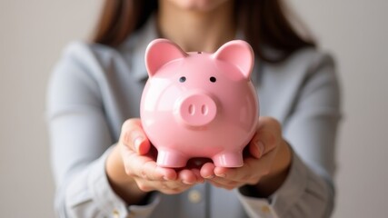 Woman holding pink piggy bank in hands Close up while in house, concept emphasizing importance of personal savings and financial responsibility.