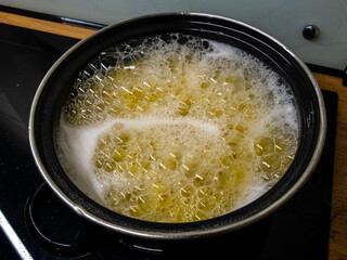 A bubbling pot of oil on the stove creates an enchanting ambiance for delicious cooking