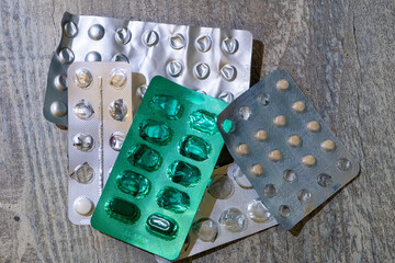 A Wide Variety of Different Medication Blister Packs Arranged Neatly on a Wooden Surface