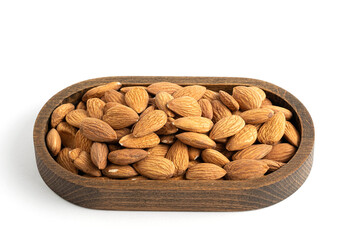 Almond in wooden bowl isolated on white background. Top view.