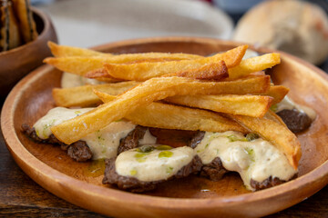Beef meat fillets with pepper sauce and fries on wooden plate Spain