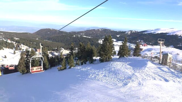 Empty Chairlifts Moving Over Snow-Covered Trees in a Peaceful Winter Landscape