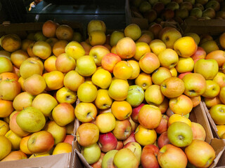 Apples for sale, Freshly harvested apples in a cardboard crate at a market. Fruit display.
