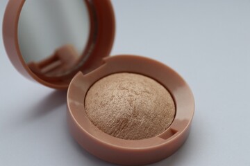 Beige pearlescent eyeshadow in an open case with a mirror
