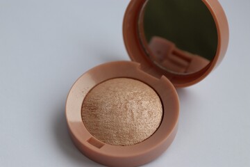 Beige pearlescent eyeshadow in an open case with a mirror