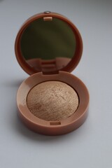 Beige pearlescent eyeshadow in an open case with a mirror