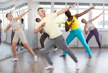 European man conducts lesson for multinational people company, teaches men and women to move...