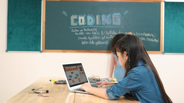 Girl writing engineering prompt by using AI software or programing system to generate AI on table with electronic main board at stem class while student writing software development plan. Pedagogy. - Powered by Adobe
