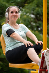 Mujer entrenando sus piernas con una máquina pública del parque de su ciudad. Fotografía Vertical