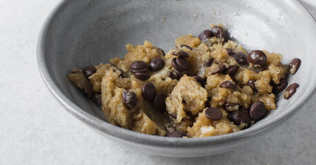 Overhead view of chocolate chip cookie dough, top view of homemade chocolate chip cookie dough in a bowl on a white background, process of making chocolate chip cookies