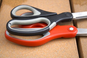 two pairs of scissors in red and black colors side by side