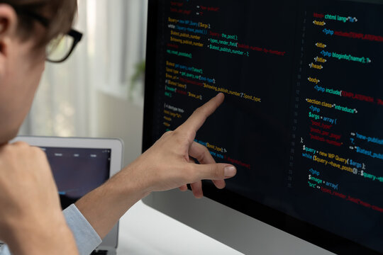 IT developer selecting by point on coding online software development information on pc comparing with laptop screen of new code program's update version firmware overall system project. Pecuniary.