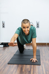 Fototapeta premium Woman performing bird dog exercise on yoga mat for core and abs workout