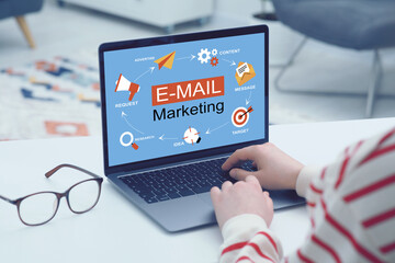Email marketing. Woman using laptop at table, closeup