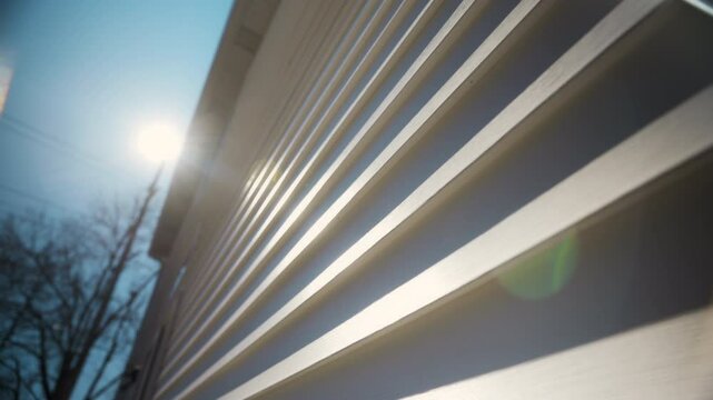 Wide view of White siding house wall with modern panels, providing a sleek and classic exterior look. move camera view