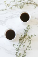 Two Cups of Coffee and Greenery on Marble