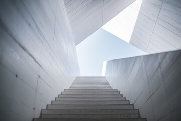 Obraz premium Modern Architectural Staircase Leading Towards a Bright Sky with Geometric Shapes