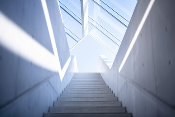 Obraz premium Minimalist Concrete Staircase Leading to Bright Skylight Under Blue Sky