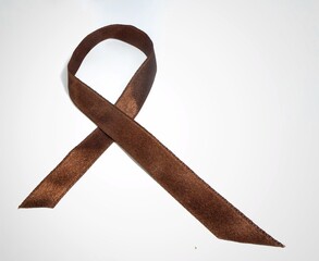 Satin Brown Tobacco and colorectal cancer  solidarity or awareness ribbon isolated on white...