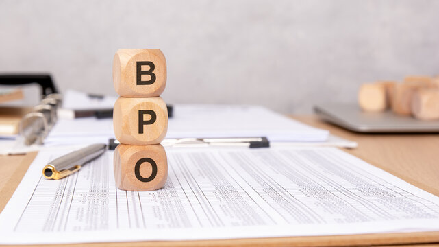 Wooden blocks with "BPO" letters on an office desk, symbolizing outsourcing, efficiency, and business.