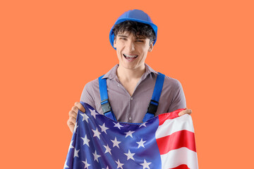 Male construction worker with USA flag on orange background