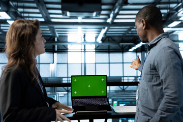 Team of server farm engineers using isolated screen mockup laptop, conducting security audits,...