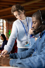 Call center manager providing guidance to african american intern, addressing questions. Customer...