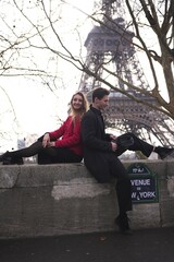 Fototapeta premium Smiling couple relaxes near Eiffel Tower in Paris