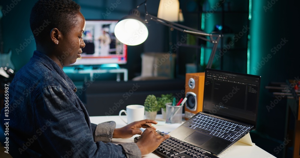 Poster teleworker in living room office using laptop to do coding for software developing, handheld camera 