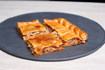 Delicious galician empanada slices resting on a slate plate
