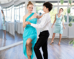 Couple of positive interested teenage dancers, boy and girl preparing for performance, rehearsing...