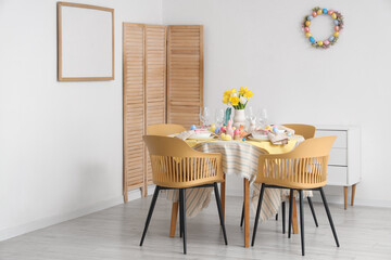 Beautiful table setting with tulip flowers and Easter decoration in dining room