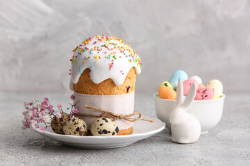 Plate with sweet Easter cake, quail eggs and gypsophila flowers on grey background