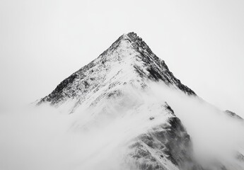 Majestic Snow-Capped Mountain Peak Surrounded by Mist and Clouds Under Dramatic Sky Offering Inspiring Nature Landscape for Adventure and Travel Themes