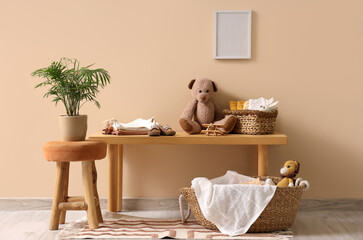 Interior of children's room with bench, baskets and baby clothes