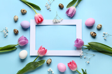 Composition with paper frame, Easter eggs and flowers on blue background