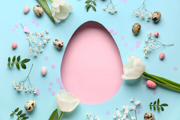 Composition with flowers, Easter eggs and pink blank egg-shaped hole on blue background