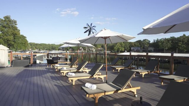 Swimming pool with sun beds on the bank of the river. Drone flight over the hotel pool. Empty sunbeds with towels. Missouri, Ozark, 4K drone Lounge chairs by the pool