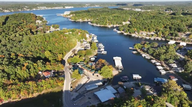 Aerial view, flying over the river, forest, small houses on the water and hotels. Missouri, Ozark In summer, green trees, landscape. Drone 4K