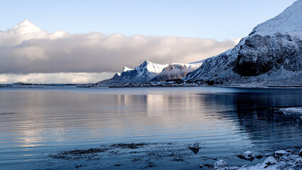 Reflection of snow-covered mountain range in a lake with calm water, Fredvan crossing, Lofoten,...