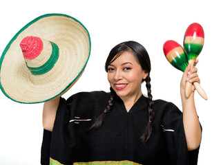 Fototapeta premium Smiling Mexican woman wearing colorful poncho and hat plays maracas, isolated on white background