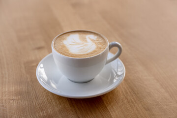 Cup of aromatic coffee on wooden table in cafe, closeup