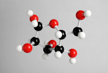 Molecule of glucose on light grey background. Chemical model